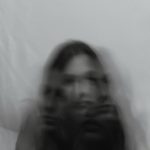 a blurry photo of a woman holding a cell phone