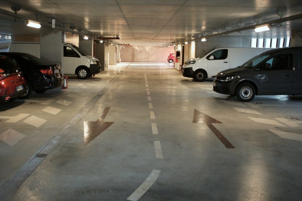 A parking garage with several cars parked in it