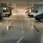 A parking garage with several cars parked in it